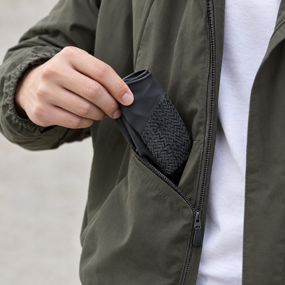 Pocket-size folded silicone shoe covers pulled from a jacket pocket